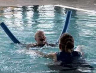 Kind schwimmt in Schwimmbecken